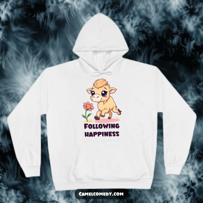 Funny, playful camel with big sparkling eyes chasing a desert flower, featured on a warm hoodie.