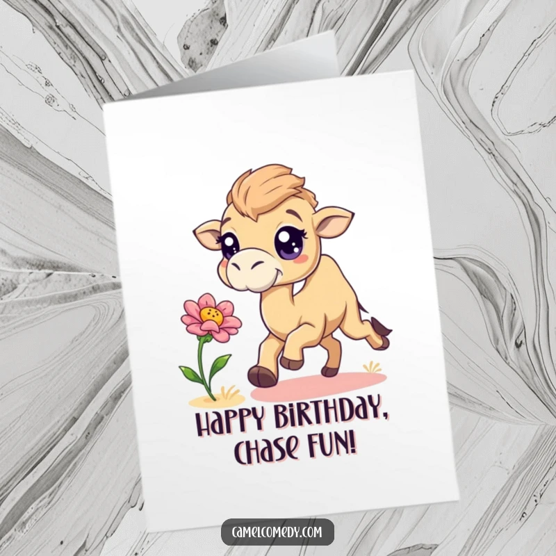 Funny Free Printable Birthday Card: Playful camel with big sparkling eyes chasing a bouncing desert flower.